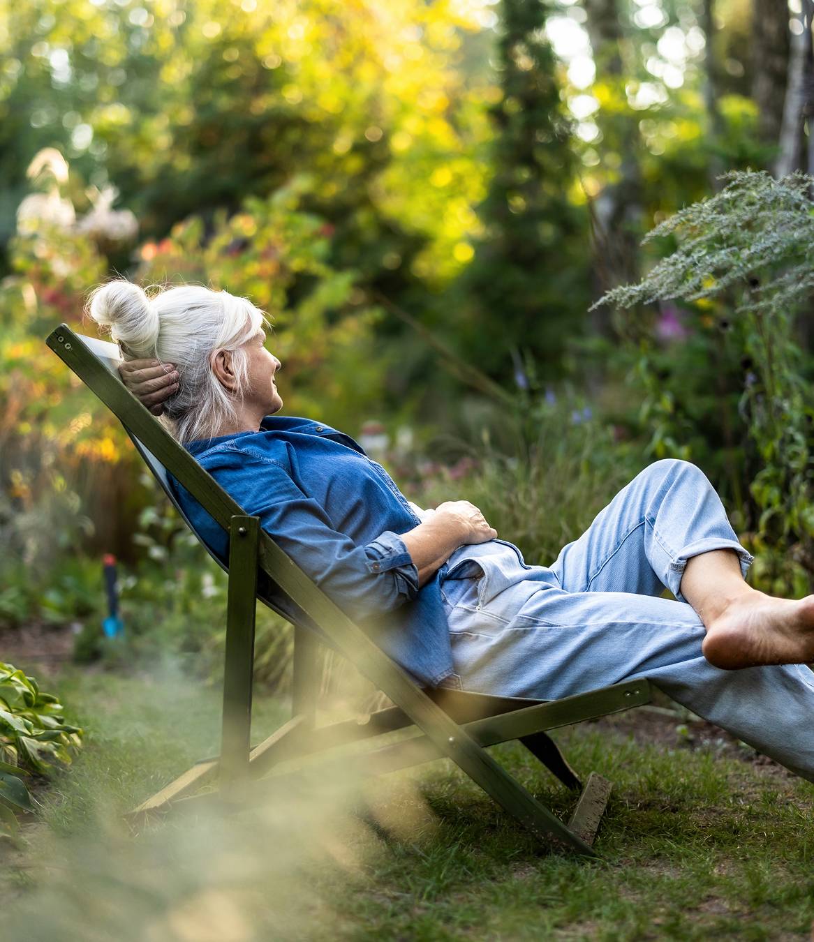 Older adult resting comfortably in a garden surrounded by greenery