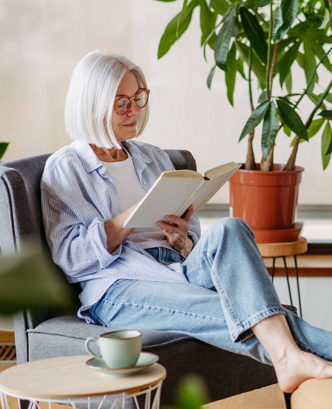 Resident enjoying a quiet moment reading in a comfortable, light-filled living space